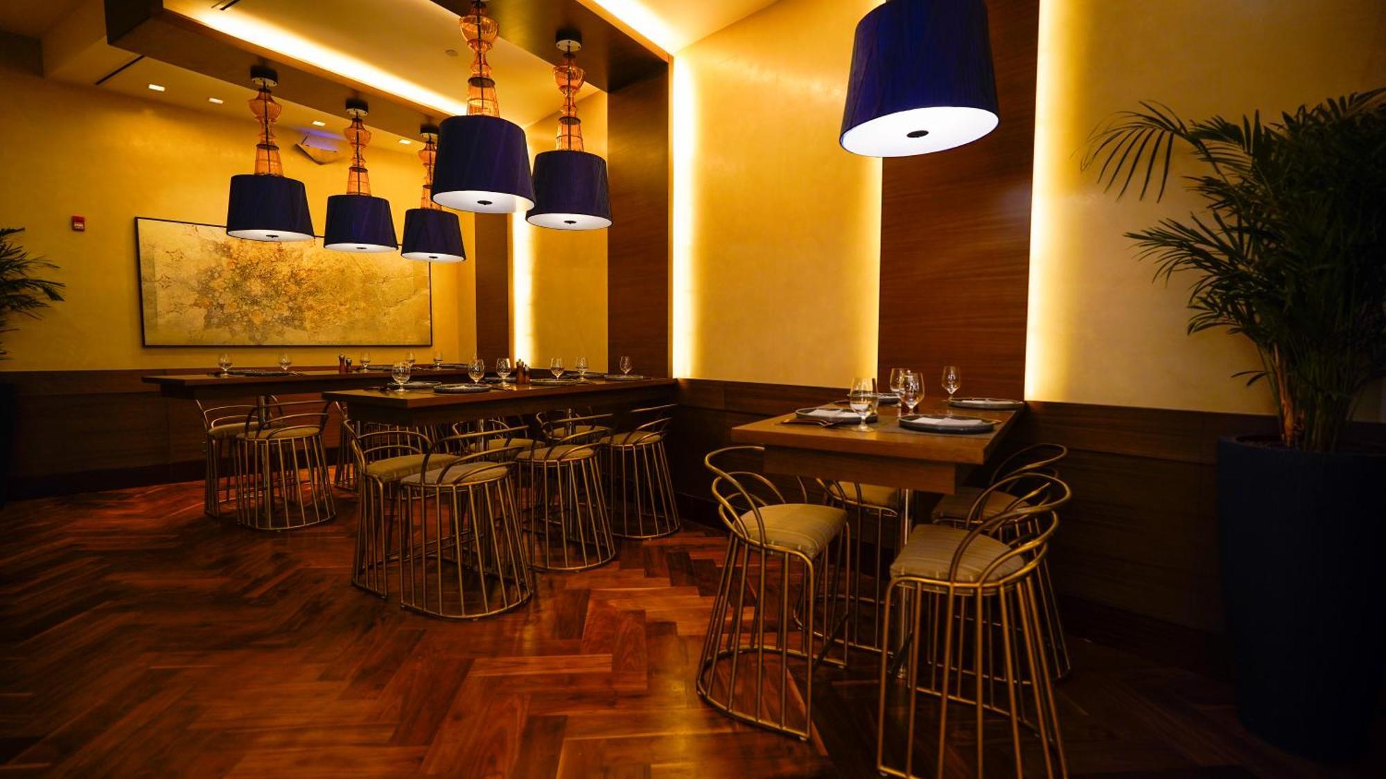 Jabal Omar Hyatt Regency Makkah Hotel Mekka Eksteriør billede The photo shows an elegantly designed restaurant interior. It features stylish seating arrangements with gold wire chairs paired with tables. The ambient lighting is warm, with a mix of recessed lights and pendant lamps that have blue shades, creatin