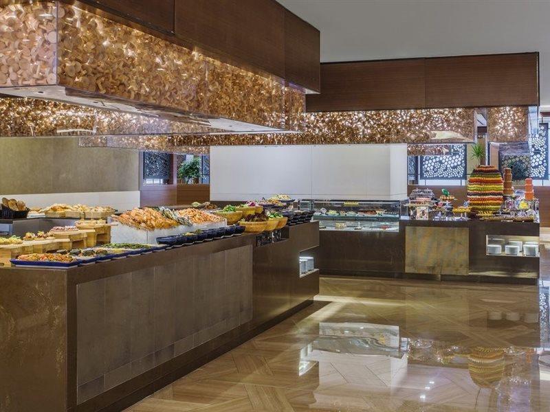 Jabal Omar Hyatt Regency Makkah Hotel Mekka Eksteriør billede The photo shows a stylish buffet area, likely in a restaurant or hotel. There are several food displays arranged on long tables with shiny surfaces. The buffet features a variety of items, which may include pastries, bread, and other dishes. The area