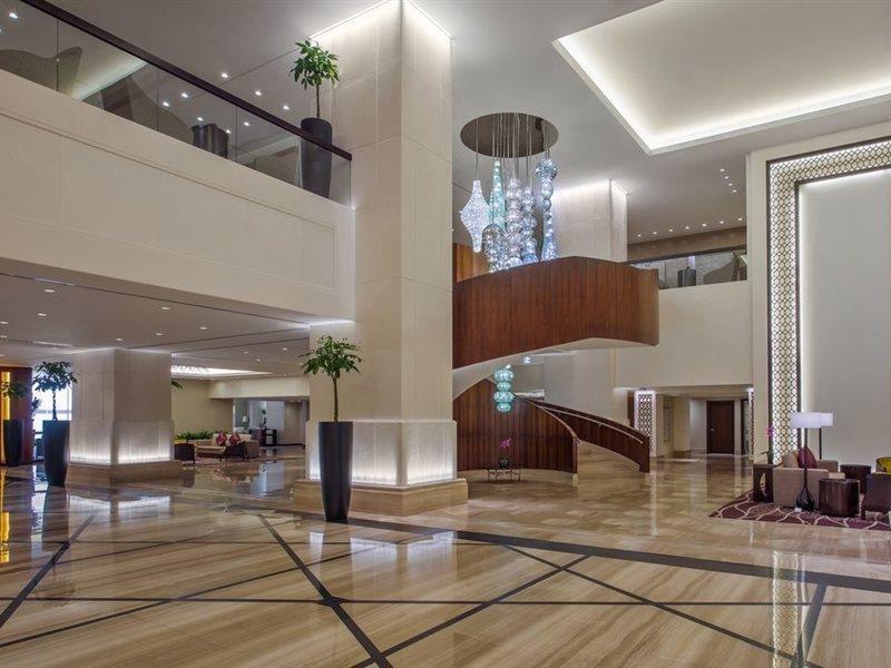 Jabal Omar Hyatt Regency Makkah Hotel Mekka Eksteriør billede The image shows a spacious and modern hotel lobby. It features elegant interior design with high ceilings and polished marble floors. A prominent wooden staircase with a stylish design is located in the center, leading to an upper level. There are de