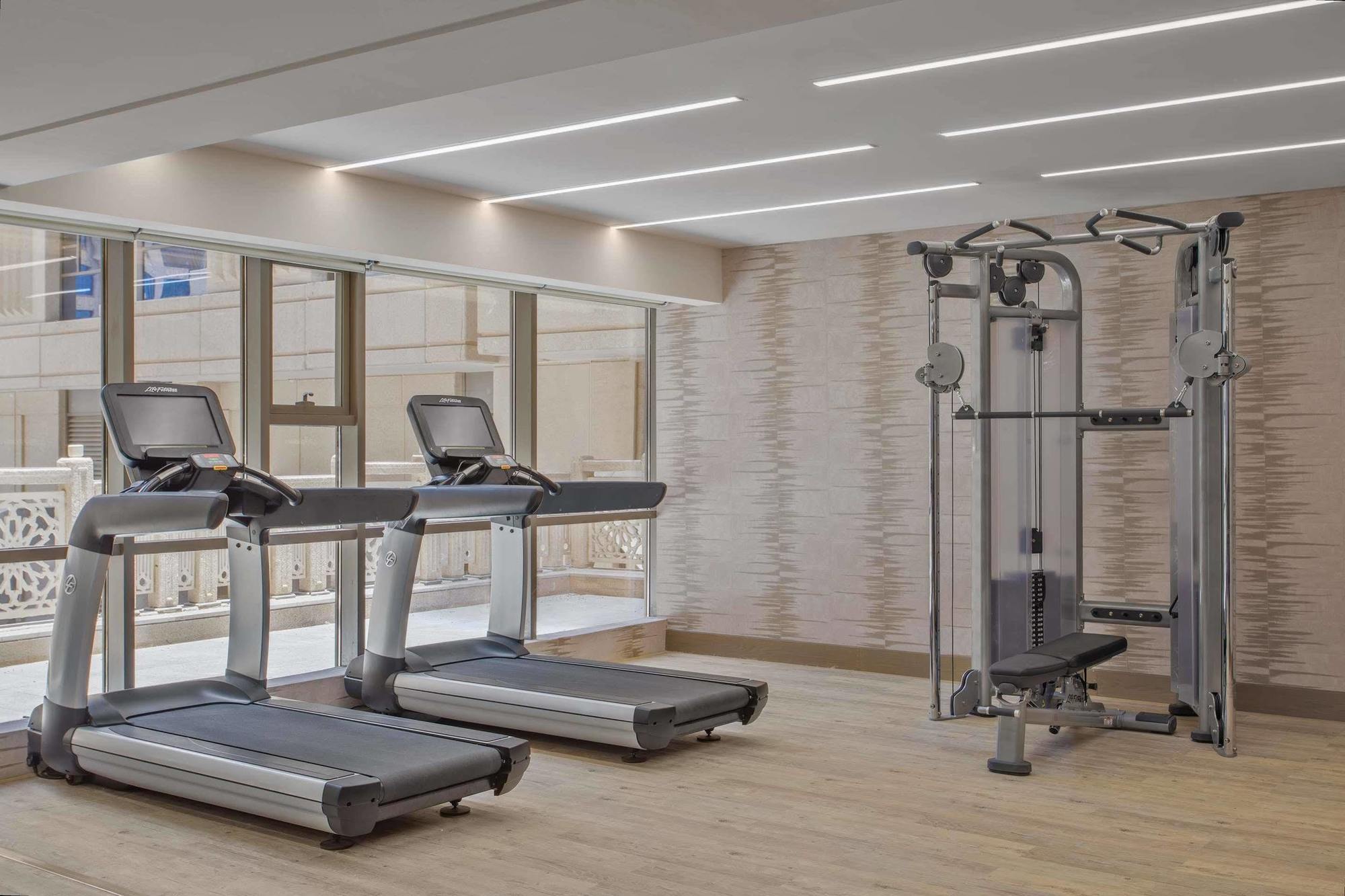 Jabal Omar Hyatt Regency Makkah Hotel Mekka Eksteriør billede The photo shows a modern gym area featuring two treadmills positioned side by side. Next to them is a multi-functional gym machine designed for strength training, which includes various attachments for different exercises. The gym has a bright, airy 