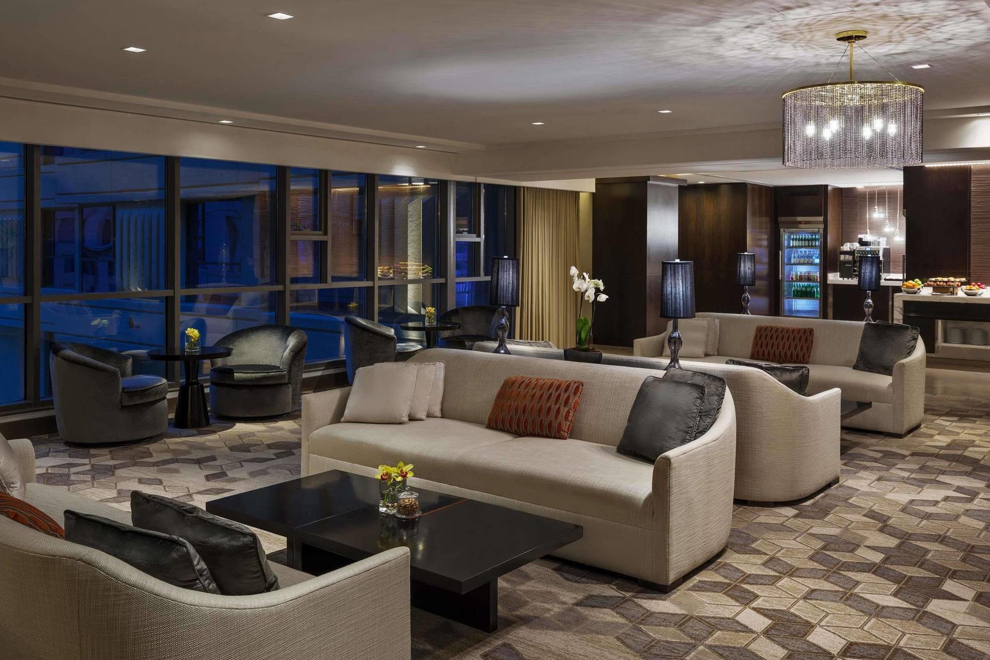 Jabal Omar Hyatt Regency Makkah Hotel Mekka Eksteriør billede The photo shows a modern and elegant lounge area. It features comfortable cream-colored sofas arranged in a cozy setting, along with dark coffee tables. The space is illuminated by warm lighting, including a stylish chandelier. Large windows allow fo